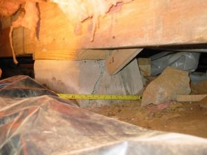 Crushed-CMU-pier-supporting- beam-in-crawlspace